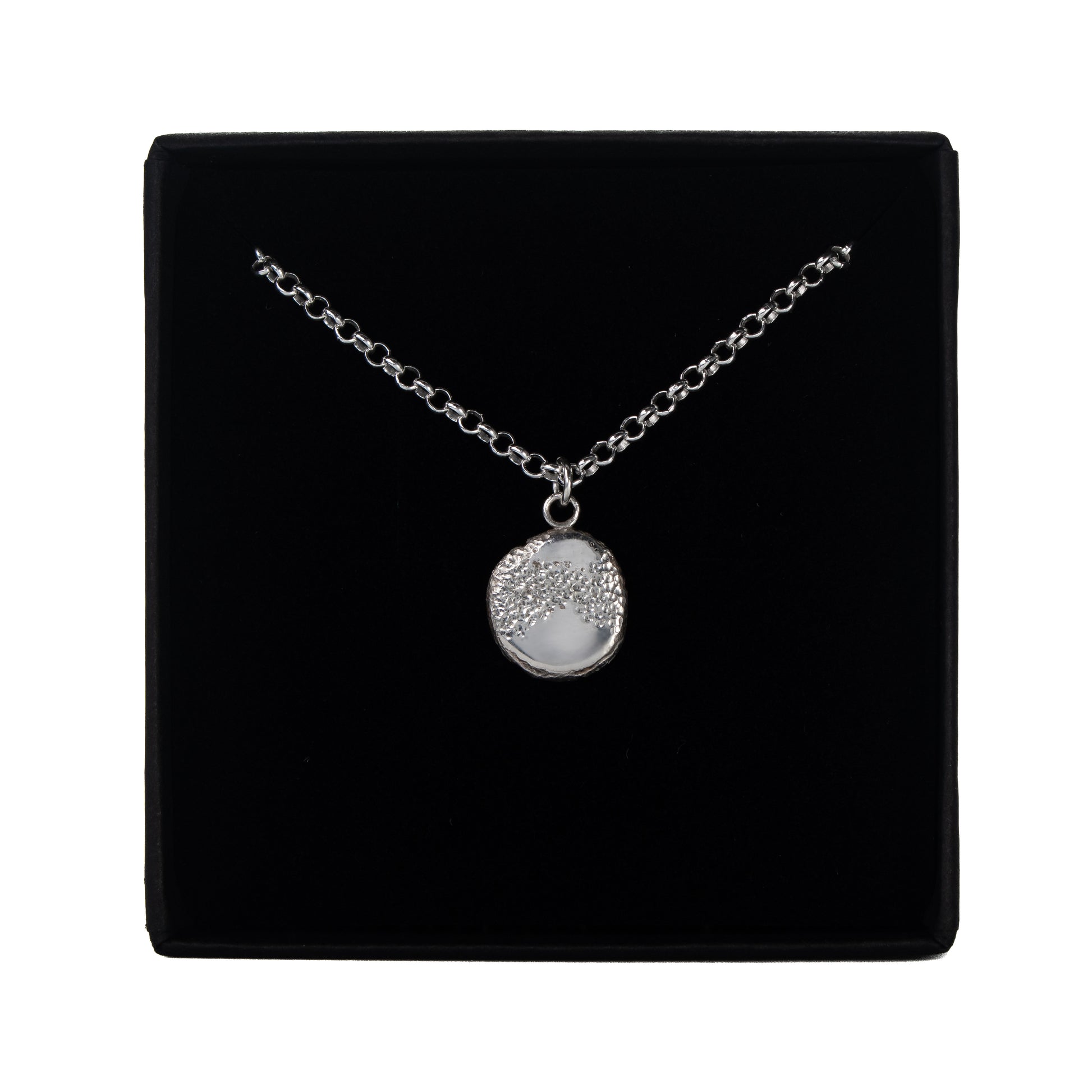 The Aether Pendant recycled organic silver necklace in its presentation box.
