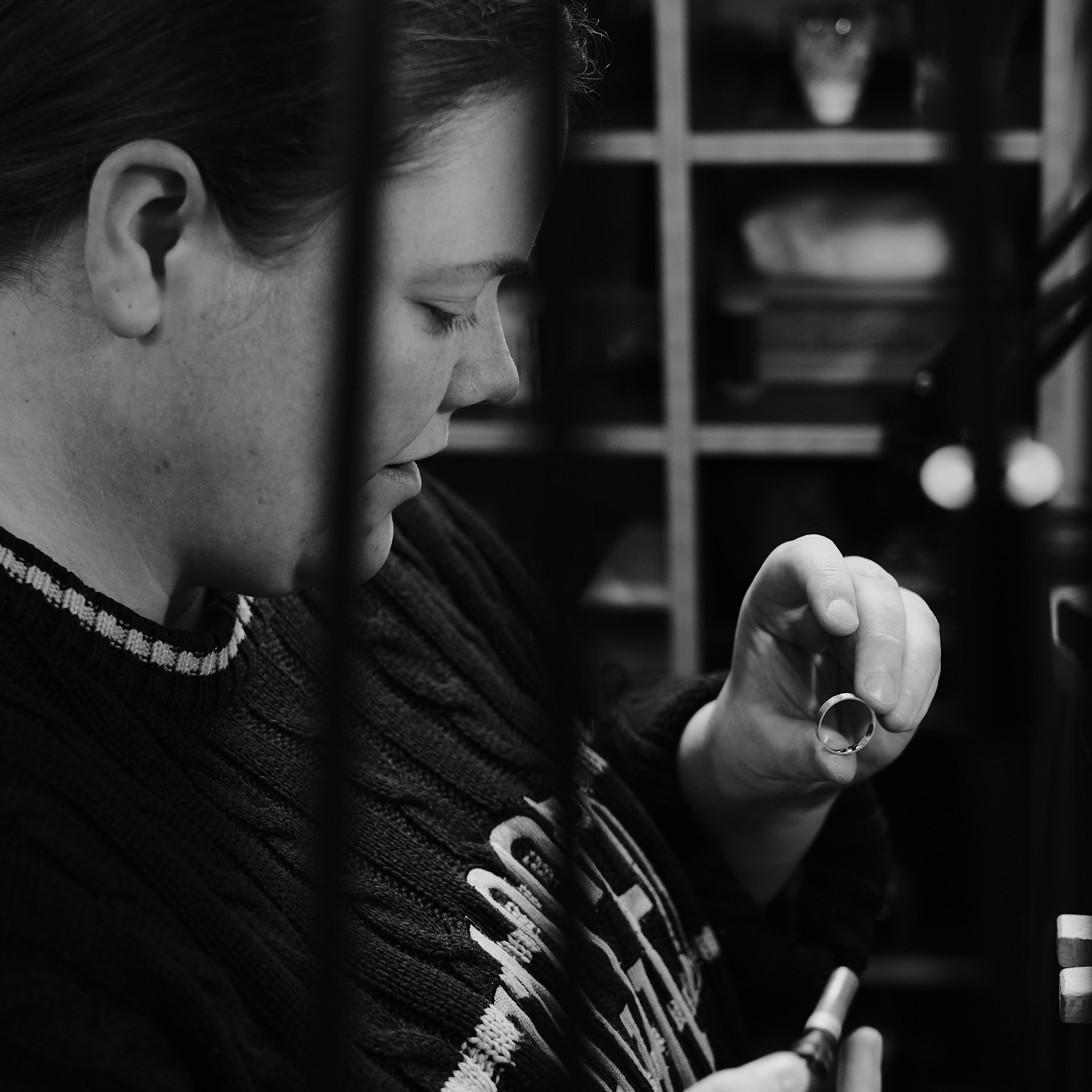 Bianca O’Neill inspecting a handmade silver ring in her studio.