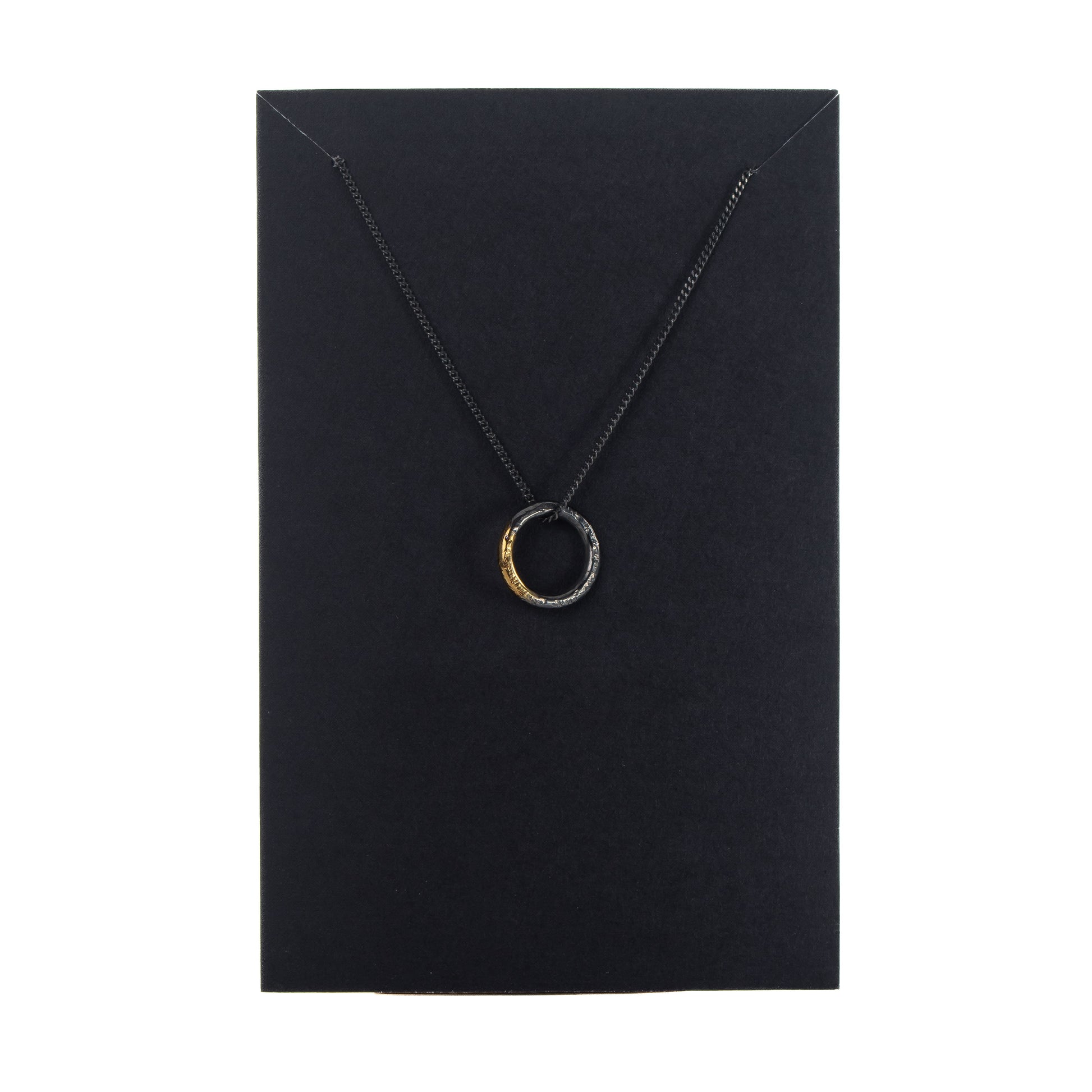 Oxidised silver circle necklace with gold detail displayed on black jewellery card
