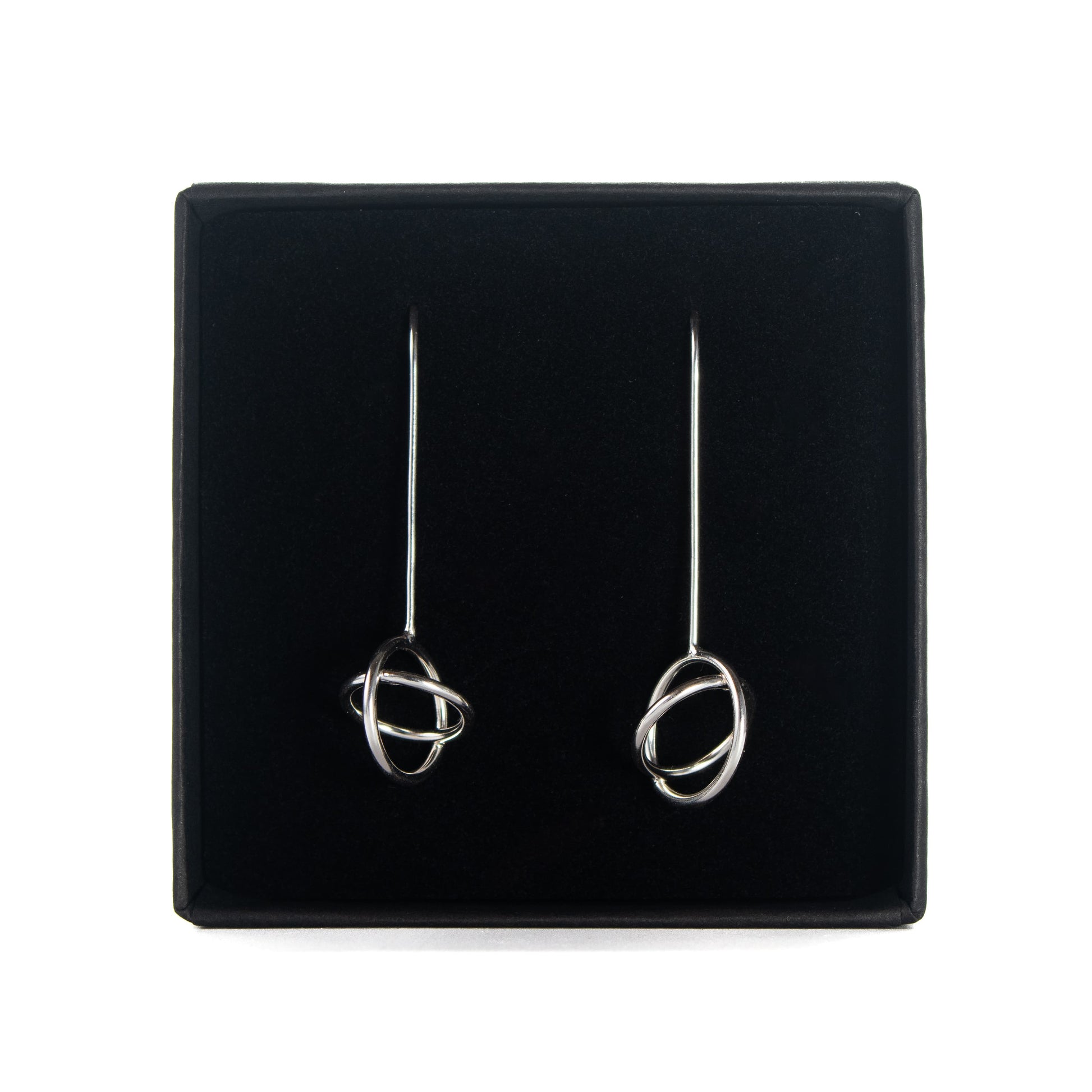 Handmade silver aperture dangle earrings in black branded jewellery box