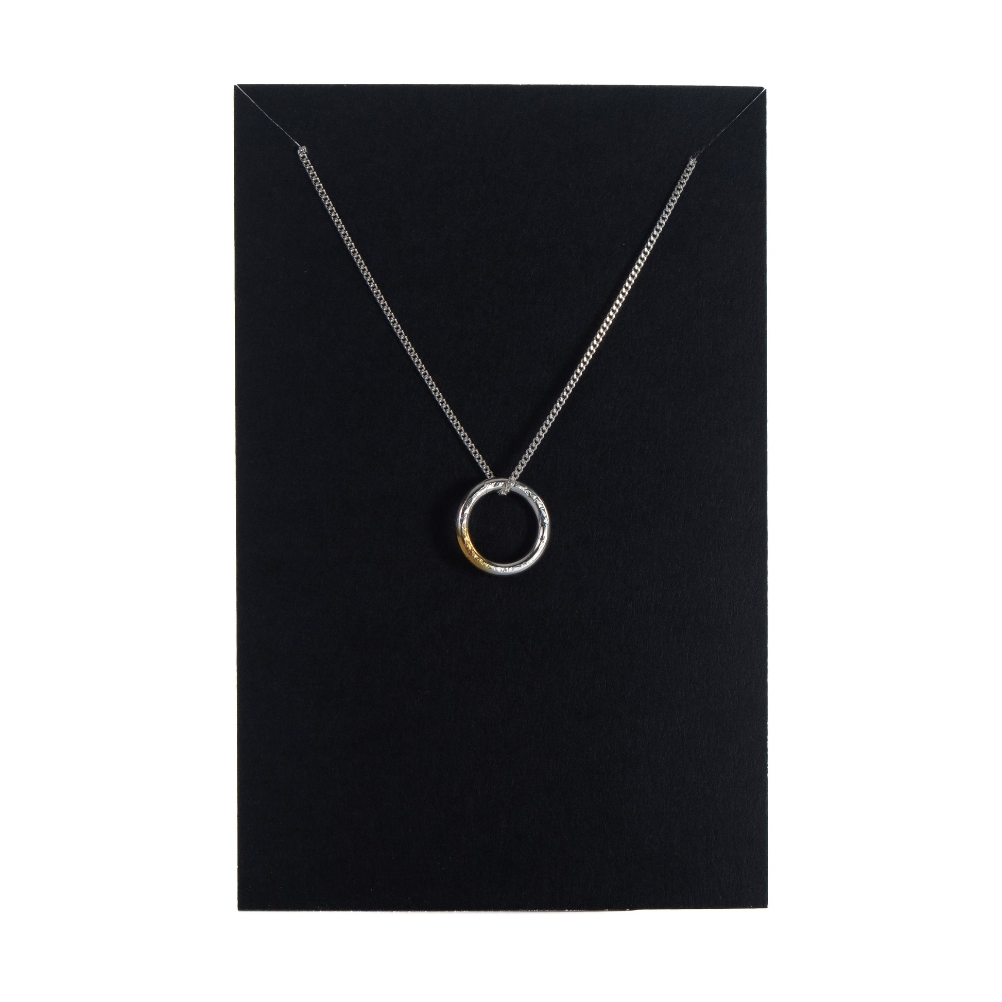 Sterling silver circle necklace with gold detail displayed on black jewellery card