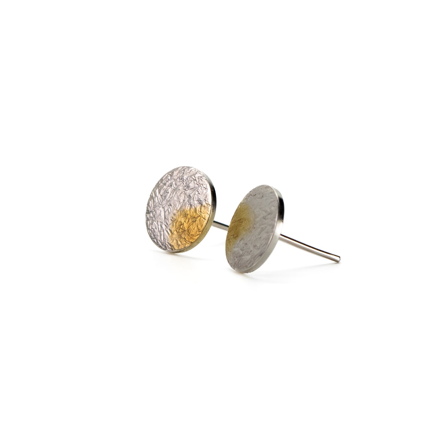 Silver gold disc stud earrings with rough hammer texture and selective gold plating, angled view