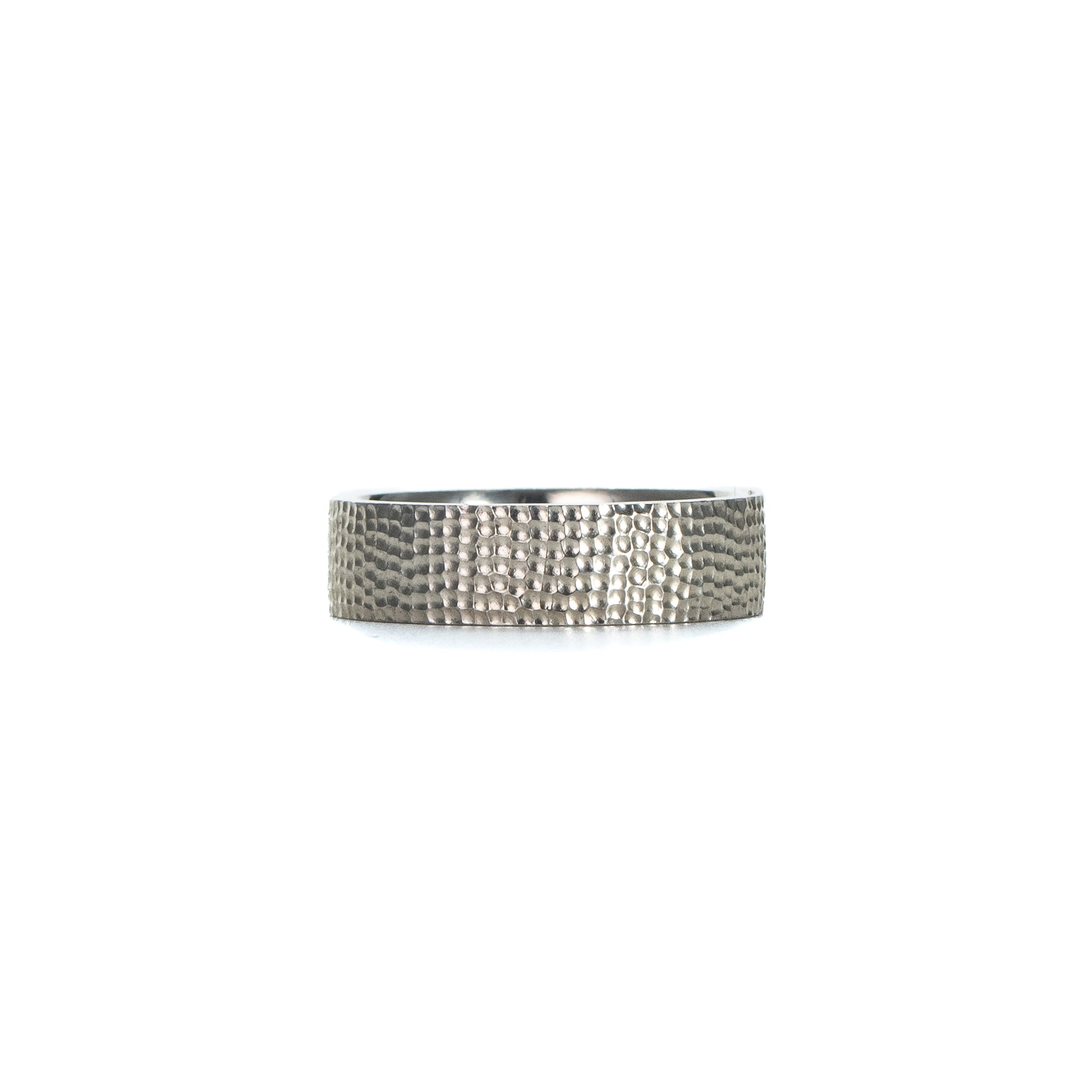 Textured silver band ring in sterling silver with a hand-carved surface on white background