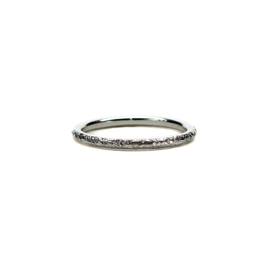 Rough hammered textured silver stacking ring on white background